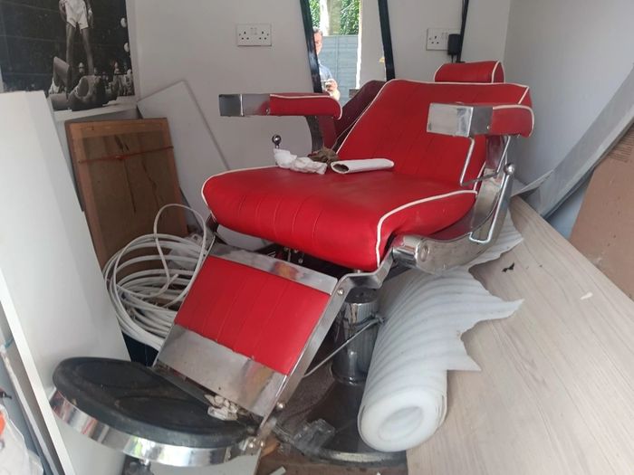 Beautiful red vintage Barbers chair with white piping