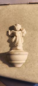 A holy water font  a small cherub angel statue .small religious decorative item,