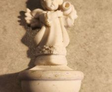 A holy water font  a small cherub angel statue .small religious decorative item,