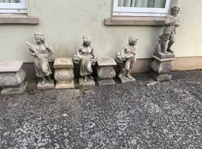 Four stone garden statues