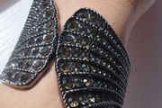 A striking wide bracelet encrusted with sparkling rhinestones.