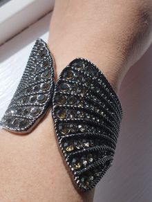 A striking wide bracelet encrusted with sparkling rhinestones.