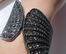 A striking wide bracelet encrusted with sparkling rhinestones.