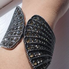 A striking wide bracelet encrusted with sparkling rhinestones.