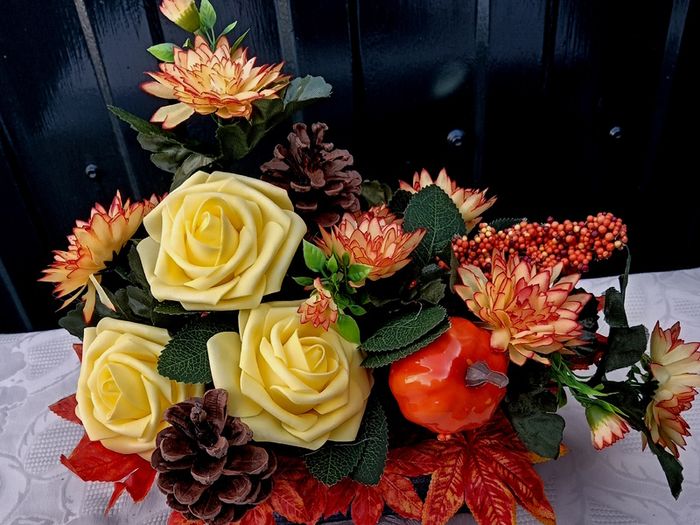 Autumnal artificial flower arrangement with roses and pumpkin