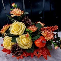 Autumnal artificial flower arrangement with roses and pumpkin