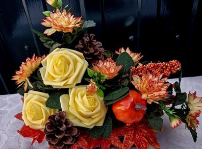 Autumnal artificial flower arrangement with roses and pumpkin