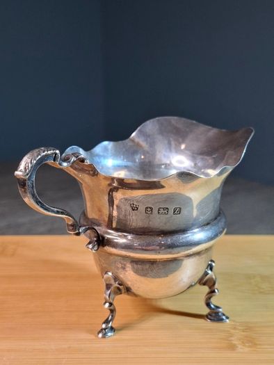 Antique silver cream jug with scalloped rim