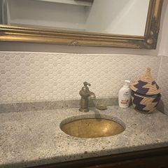 Bathroom sink, tap, drawers and mirror.