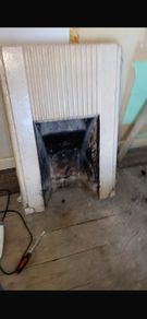 Cast iron fireplace with cream speckled enamel finish.