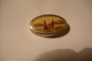 a antique pill box with golfer on it