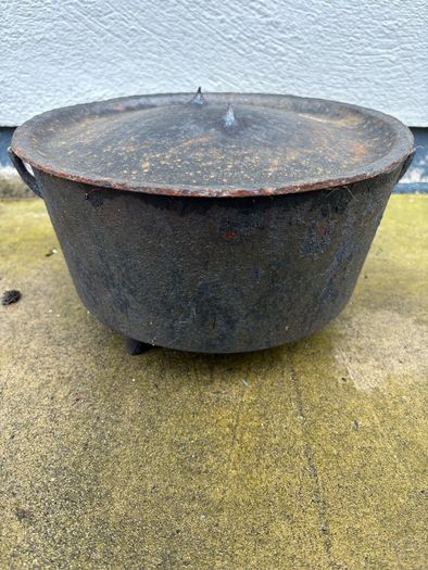 Antique cast iron tri-legged dutch oven and lid.