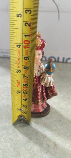 Infant of Prague devotional figurine featuring ornate red and gold robes and a matching crown.