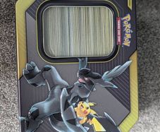 Box of mystery Pokemon in Pikachu and Zekrom tin (Pikachu and Zekrom are not included)