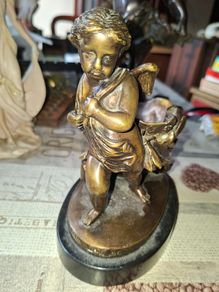 Antique French 19th century Bronze Sculpture Auguste Moreau featuring a Winged Putto Cherub Cupid carrying a shell or cornucopia like vessel, mounted on a marble base
