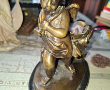 Antique French 19th century Bronze Sculpture Auguste Moreau featuring a Winged Putto Cherub Cupid carrying a shell or cornucopia like vessel, mounted on a marble base