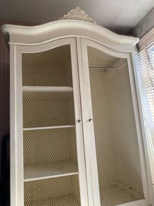 Large armoire with distressed finish, carvings and chicken wire detail
