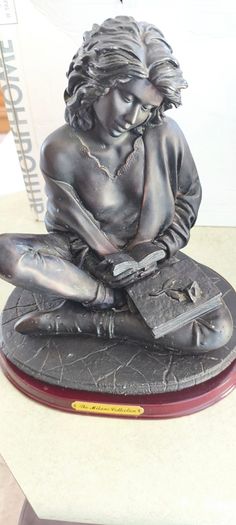 Bronze-toned sculpture of a woman reading, often titled -Reading Time Girl-  produced by The Milano Collection