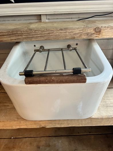 Heavy vintage ceramic basin with a built-in metal rack.