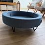 Large Round Blue Ottoman / Footstool with Storage  Stylish round ottoman with a dark denim-blue cushioned top, textured lighter blue base and black metal legs.  The top lifts off to reveal a handy storage space. Perfect as a footstool or styled with a tra Image 3
