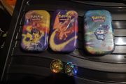 Three Pokemon tins with two coins.