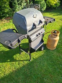 Gas barbecue and bottle.
