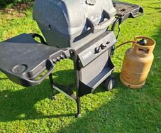 Gas barbecue and bottle.