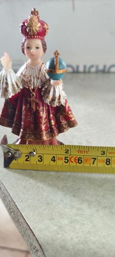 Infant of Prague devotional figurine featuring ornate red and gold robes and a matching crown.