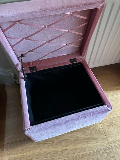 pink velour covered stool with interior storage space moves easily on castors
