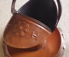 Arts and Crafts era embossed copper helmet coal scuttle with dish