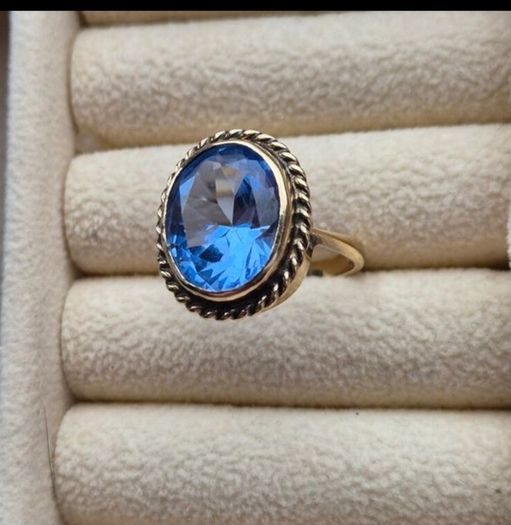 Beautiful 9K gold ring featuring a stunning large oval blue stone.