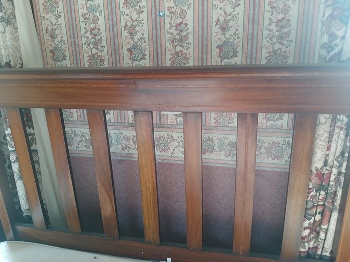 Wooden bed headboard and floral armchair