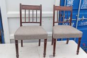 Two vintage mahogany dining chair with a pediment-style top rail, turned spindle back and turned front legs seat in a textured gray fabric