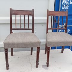 Two vintage mahogany dining chair with a pediment-style top rail, turned spindle back and turned front legs seat in a textured gray fabric