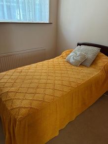 Single bed with dark wood headboard