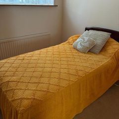 Single bed with dark wood headboard
