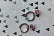 A beautiful pair of  sterling silver hoop earrings featuring small encrusted zircons and a dazzling ruby pink halo pendant.