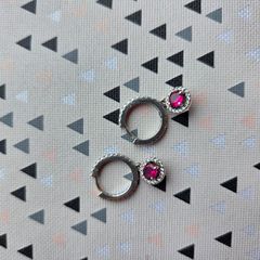 A beautiful pair of  sterling silver hoop earrings featuring small encrusted zircons and a dazzling ruby pink halo pendant.