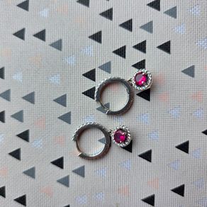 A beautiful pair of  sterling silver hoop earrings featuring small encrusted zircons and a dazzling ruby pink halo pendant.