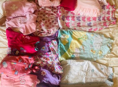 10 all in ones, 3 baby sleep bag, 4 pink blankets
