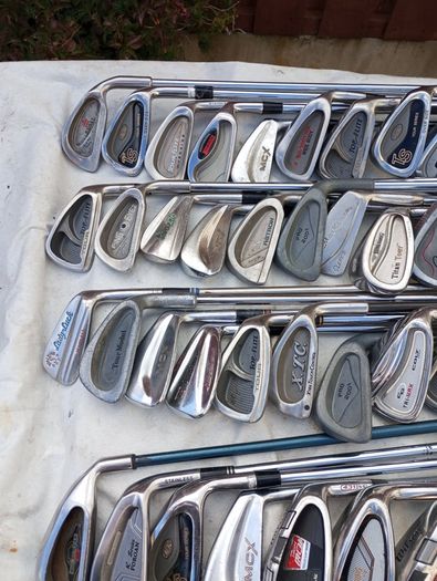 A selection of golf clubs and bags. All right handed clubs.