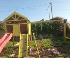 Playhouse with swings, slide, look out tower, picnic table and basketball hoop