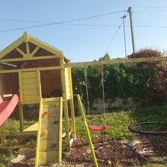 Playhouse with swings, slide, look out tower, picnic table and basketball hoop