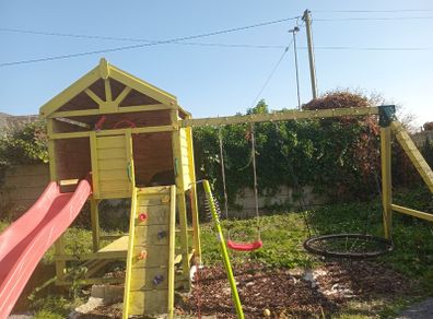Playhouse with swings, slide, look out tower, picnic table and basketball hoop