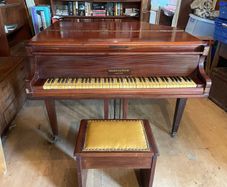 a circa-1931 Monington & Weston baby grand with matching stool.