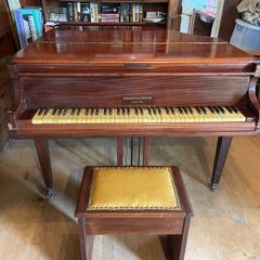 a circa-1931 Monington & Weston baby grand with matching stool.