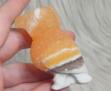 orange calcite parrot carving