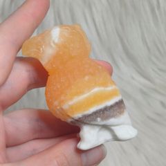 orange calcite parrot carving