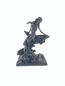 Girl sitting on a dolphin figurine