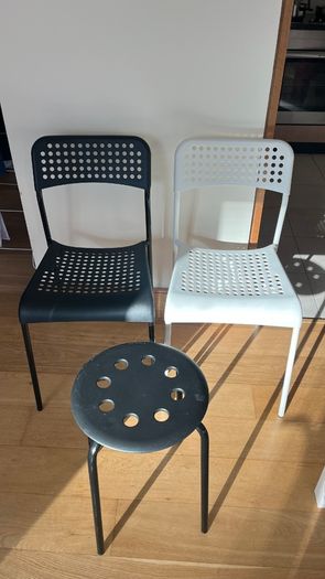 2 IKEA Adde dining chairs (1 black, 1 white) and 1 IKEA Marius stool (black).